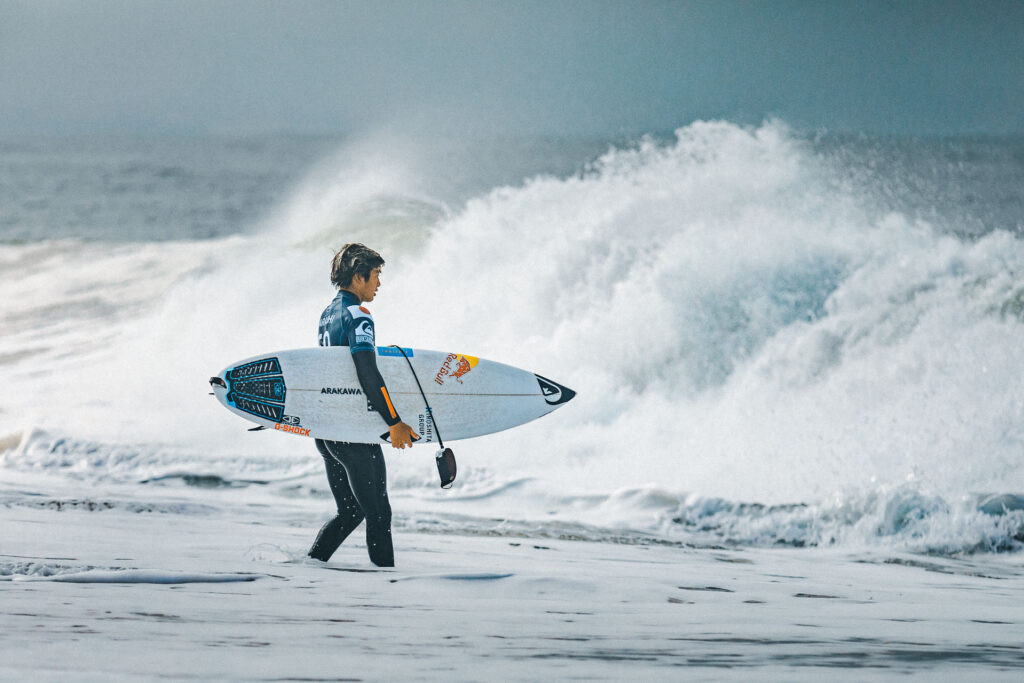 Pro Surfer Kanoa Igarashi (Japan) watching the Atlantic ocean, heavy shore breaks in the background. by ondrej kolacek