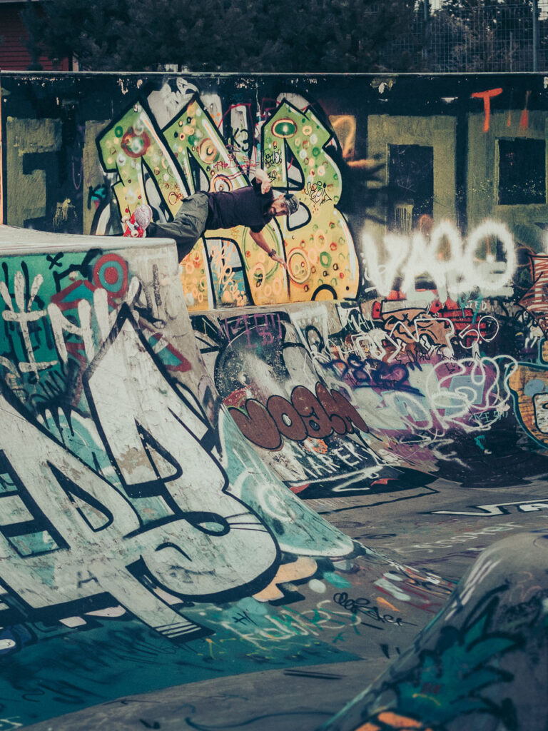 Skateboard riding the graffiti covered bowl at the skatepark in Zurich Allmend by Ondrej Kolacek