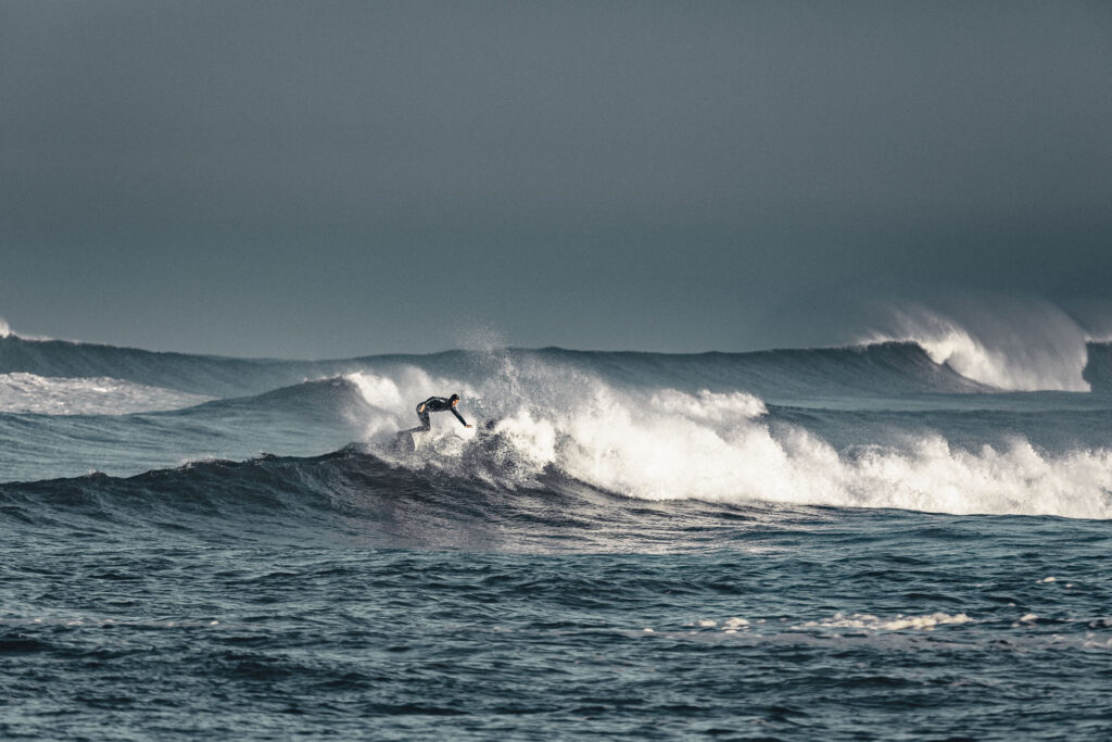 Insane waves approaching the beaches of la graviere - Hossegor, a surfer is in the water, the sky is very moody