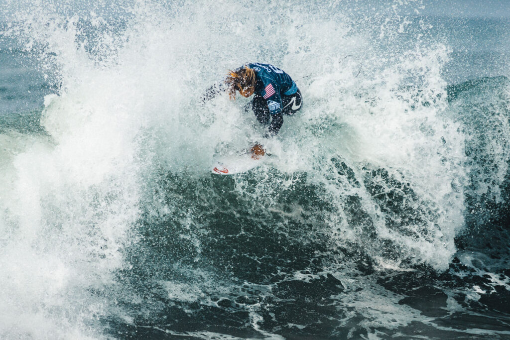 Pro Surfer Connor Coffin (USA) on top of a wave, water is splashing all around
