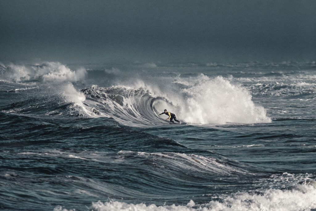 Insane waves approaching the beaches of la graviere - Hossegor, a surfer is in the water by ondrej kolacek