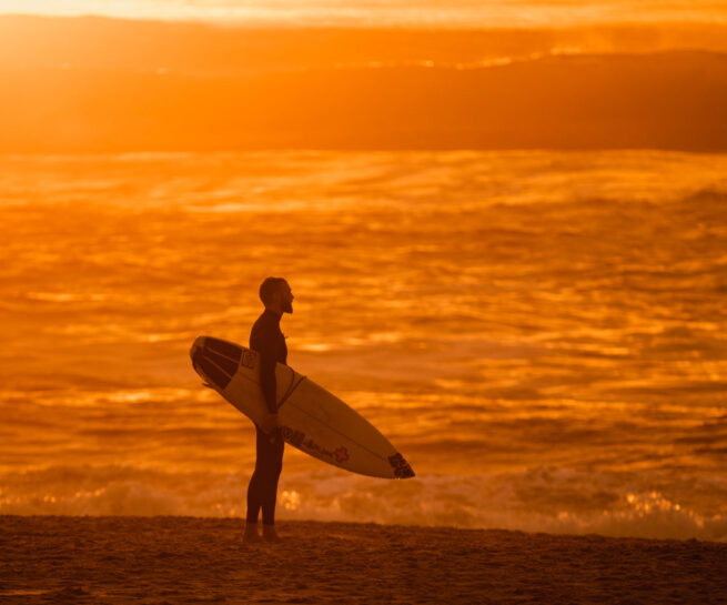 Surfer at the beach during sunset by ondrej kolacek