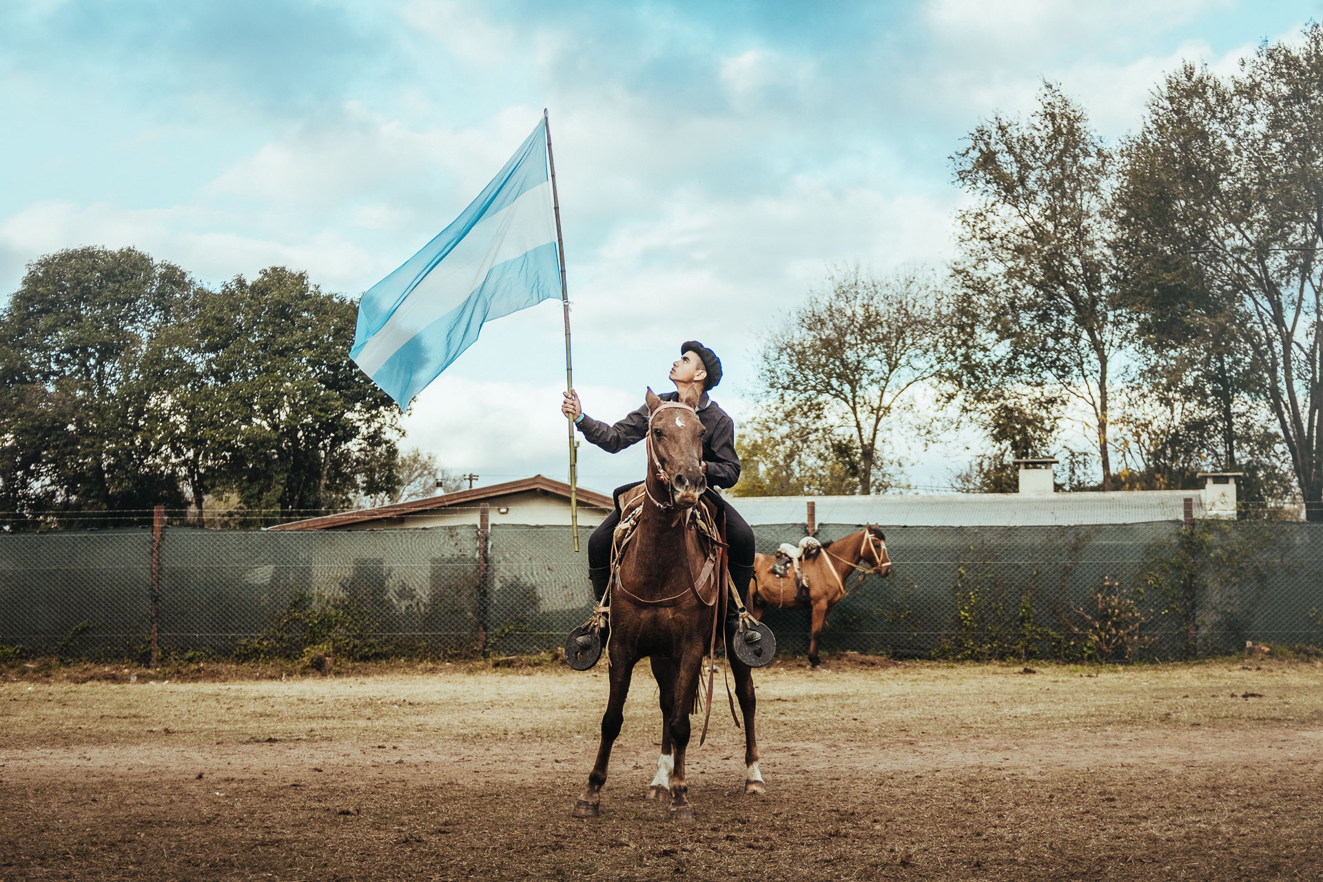 Gaucho Holding Argentina Flag sitting on a horse by Ondrej kolacek