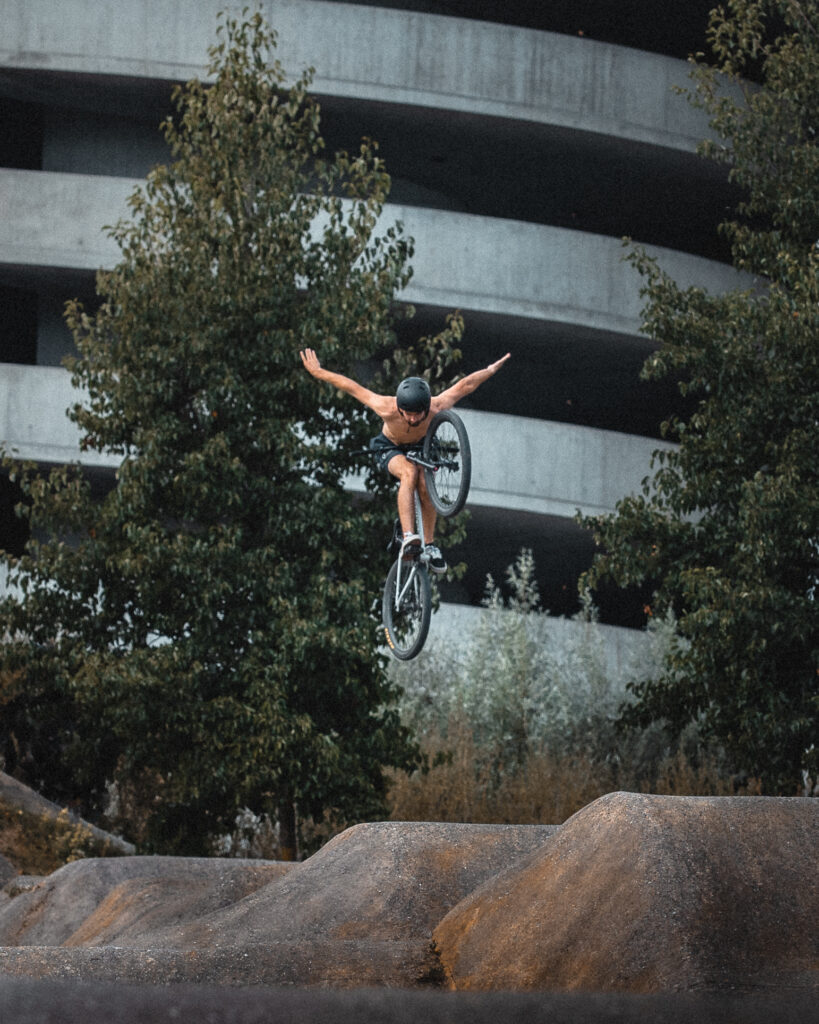 guy on a mountain bike doing a Tuck no hander at the pump track Zurich Allmend by Ondrej kolacek