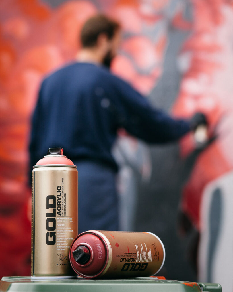 Graffiti artist is spraying a wall by Ondrej Kolacek