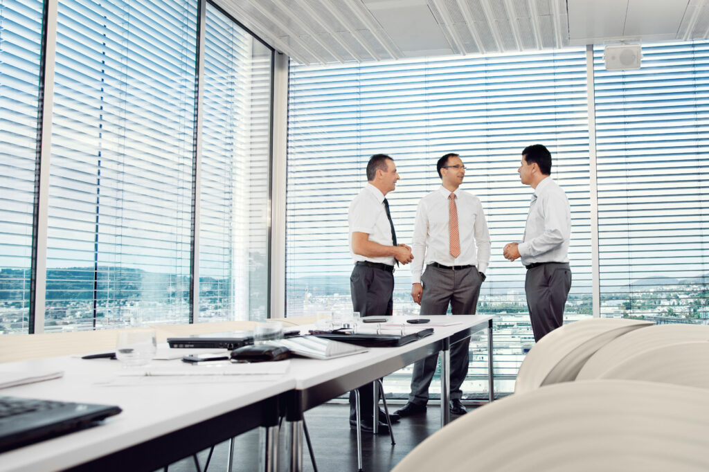 three guys in a office retouched