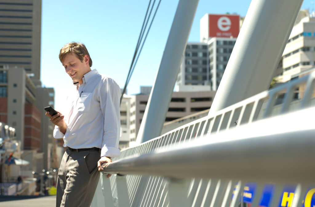 Guy on a bridge watching his mobile phone unretouched